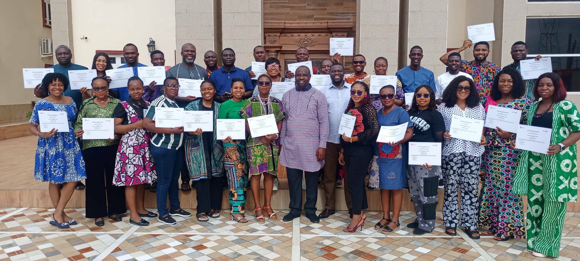 Participants proudly displaying their certificates upon completion of the training.