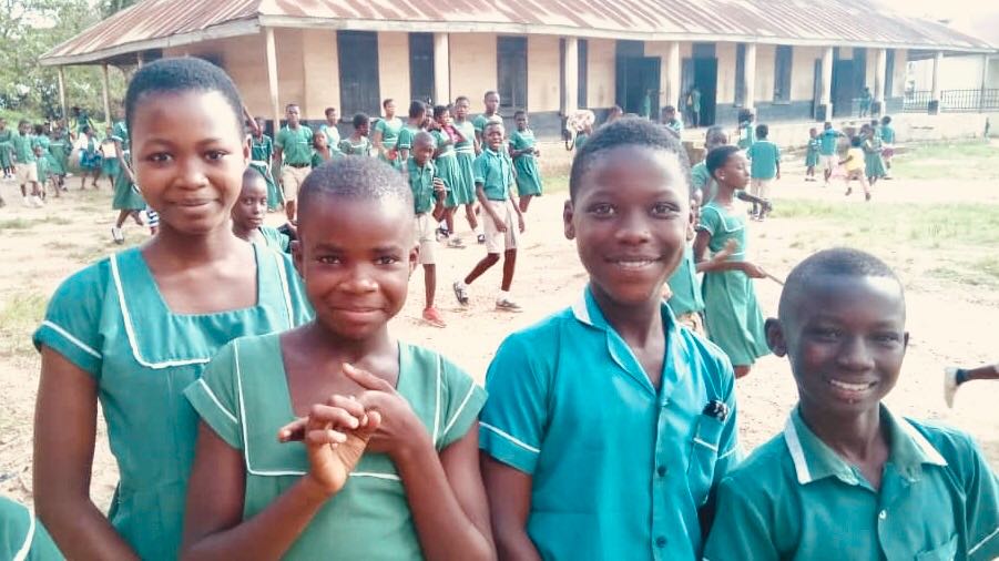 Students outside Ghana school smiling for a photo